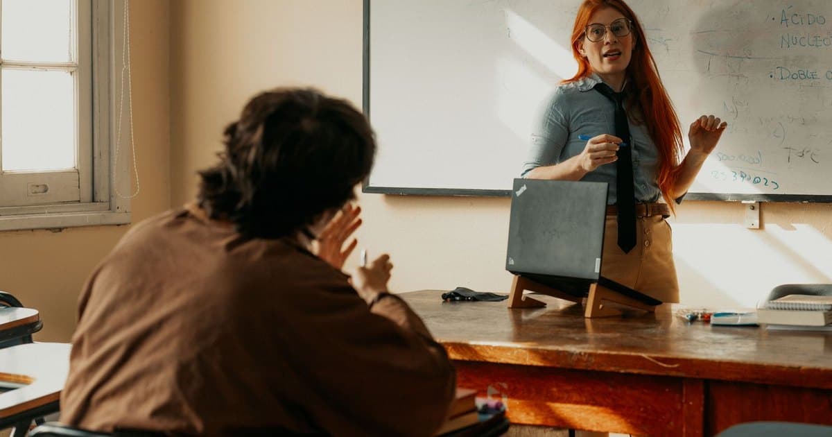 Docente dando clase frente al pizarrón