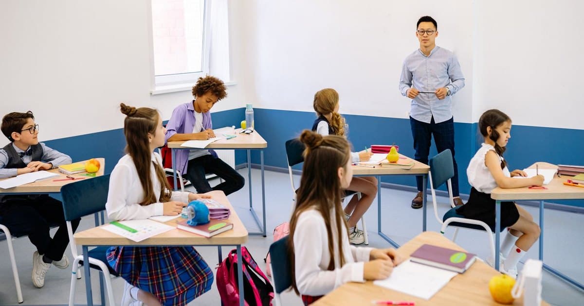 Docente dando clase en un aula con alumnos